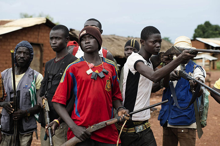 République centrafricaine, Njoh, 24 septembre 2013. Des hommes se réclamant des combattants anti-balaka, opposés aux soldats de la Séléka, posent avec leurs armes dans la rue principale de la ville de Njoh. © Michaël Zumstein / Agence VU' pour Le Monde Central African Republic, Njoh, September 24, 2013 Men claiming to be anti-Balaka fighters, opposed to the Seleka, are seen posing with their weapons in the main street of Njoh. © Michaël Zumstein / Agence VU' for Le Monde