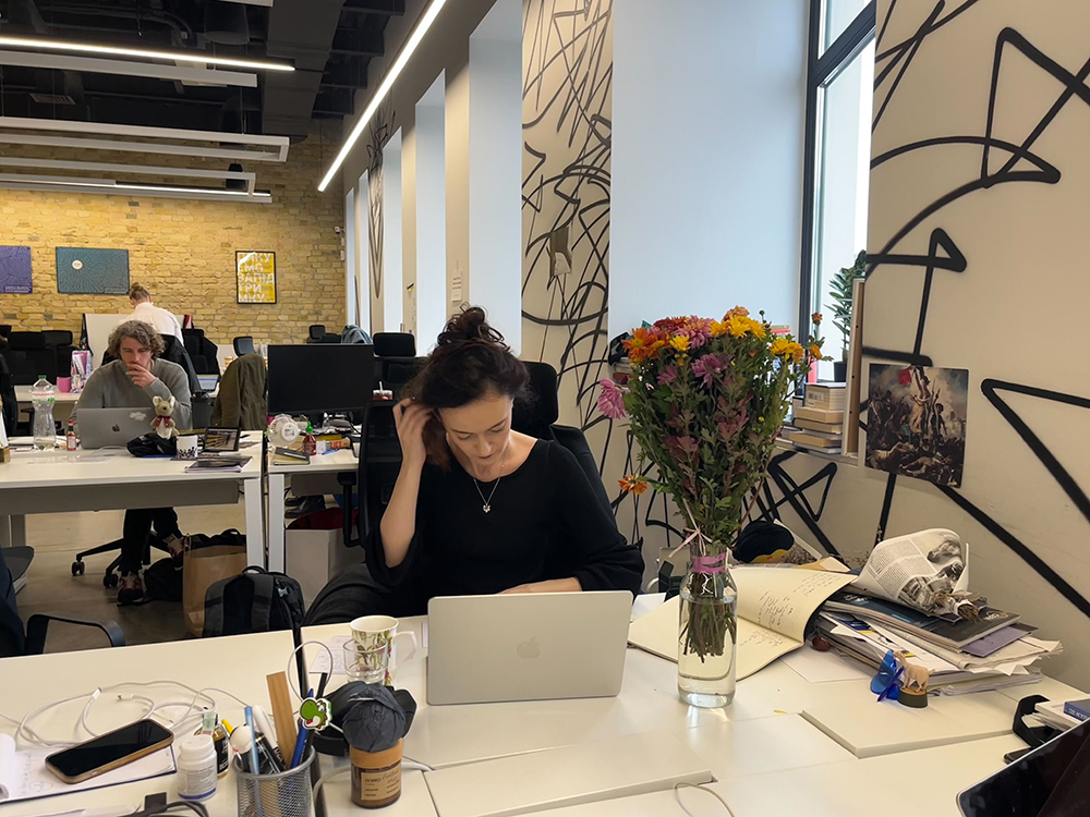 La rédactrice en chef, Olga Rudenko, signe des cartes d'anniversaire pour l'équipe le 11 novembre 2025, jour du quatrième anniversaire du Kyiv Independent, à Kyiv, en Ukraine. (©The Kyiv Independent)