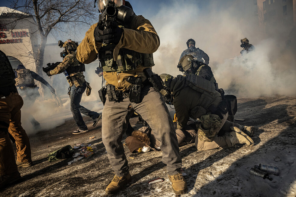 Des agents fédéraux armés arrêtent un manifestant dans une rue de Minneapolis envahie de gaz lacrymogène, après qu’Alex Pretti a été abattu par des agents. Photographie: David Guttenfelder / The New York Times