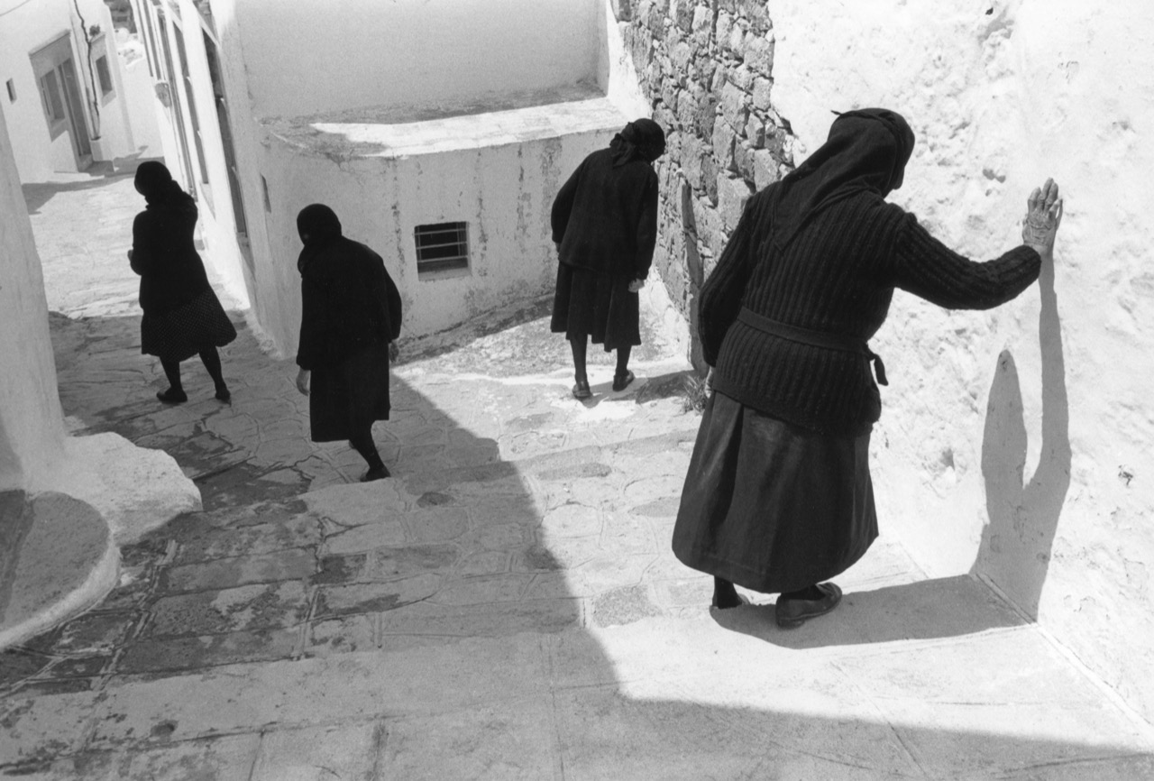 La Noire Vieillesse. Île de Patmos, Grèce. 1981 Je sors du monastère de Saint-Jean après l’office de Pâques et je descends vers le port de Patmos. Je rattrape dans les escaliers, quatre veuves vêtues de noir, des taches d’encre de chine contre un mur blanc, quatre ombres de la mort qui descendent cahin-caha l’escalier de la vie. J’appuie sur le bouton quand les quatre silhouettes se séparent et quand la dernière, celle qui marche le plus difficilement, celle qui est la plus lente, s’appuie de la main contre le mur tout chaulé, pour ne pas tomber, pour pouvoir remonter demain, encore et encore, dire la prière à Saint Jean et au Christ.Texte et photographie François Le Diascorn