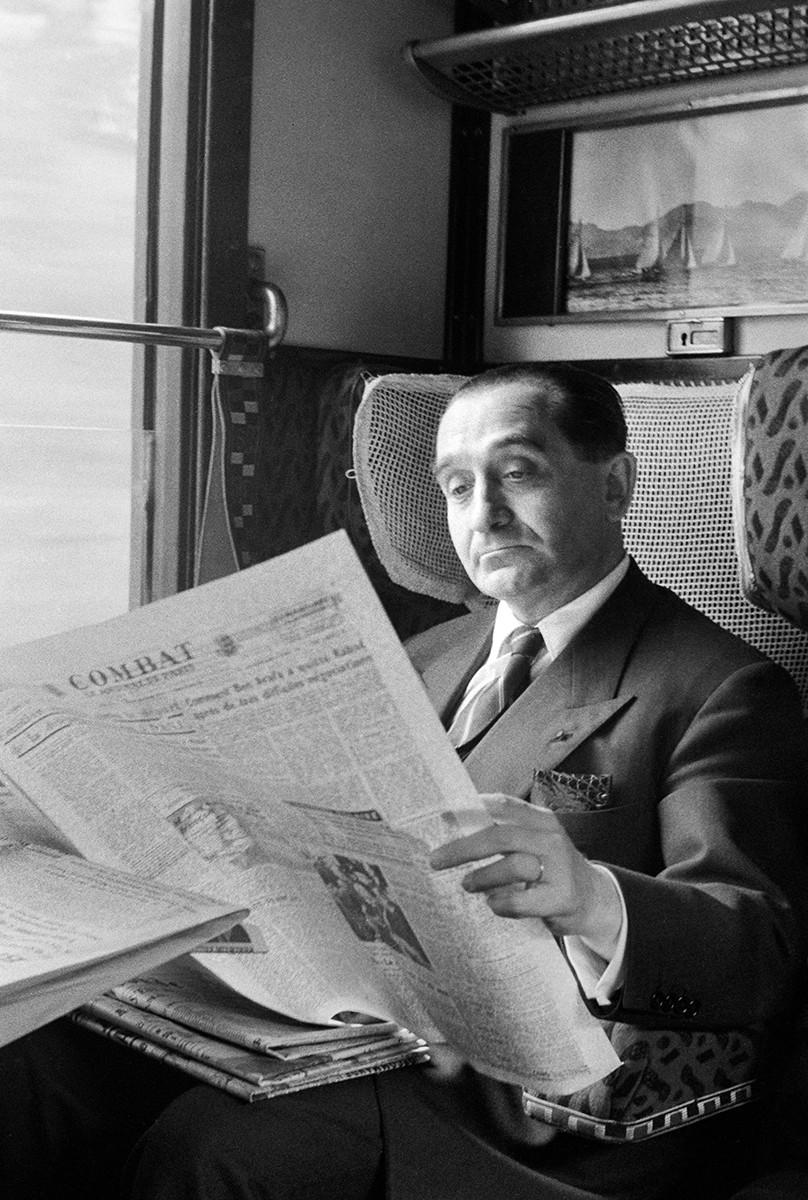 « Revue de presse. Pierre Mendès France (1907-1982) lisant le journal Combat dans le train le conduisant en Bretagne, pendant la campagne électorale du Front Républicain. France, 1955. - Photographie Jean Marquis / Roger-Viollet