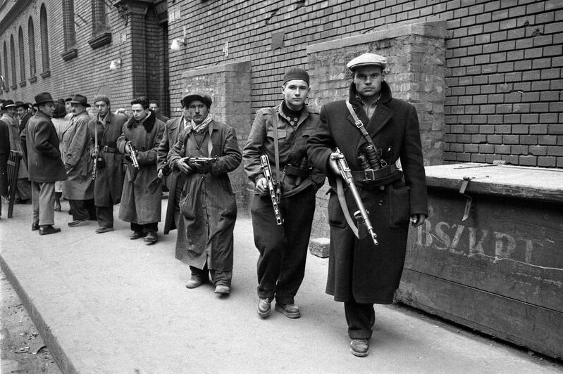 Hongrie, Budapest 1956 - Le 23 octobre, une manifestation étudiante à Budapest a dégénéré ; les étudiants ont demandé la reconduite d’Imre Nagy comme Premier ministre. La police secrète (AVO) n’a pas pu gérer la situation ; L’armée a pris le parti des manifestants. Combattants de la liberté devant le bâtiment de la police politique. Photographie Les Reporters Associés / Gamma-Rapho